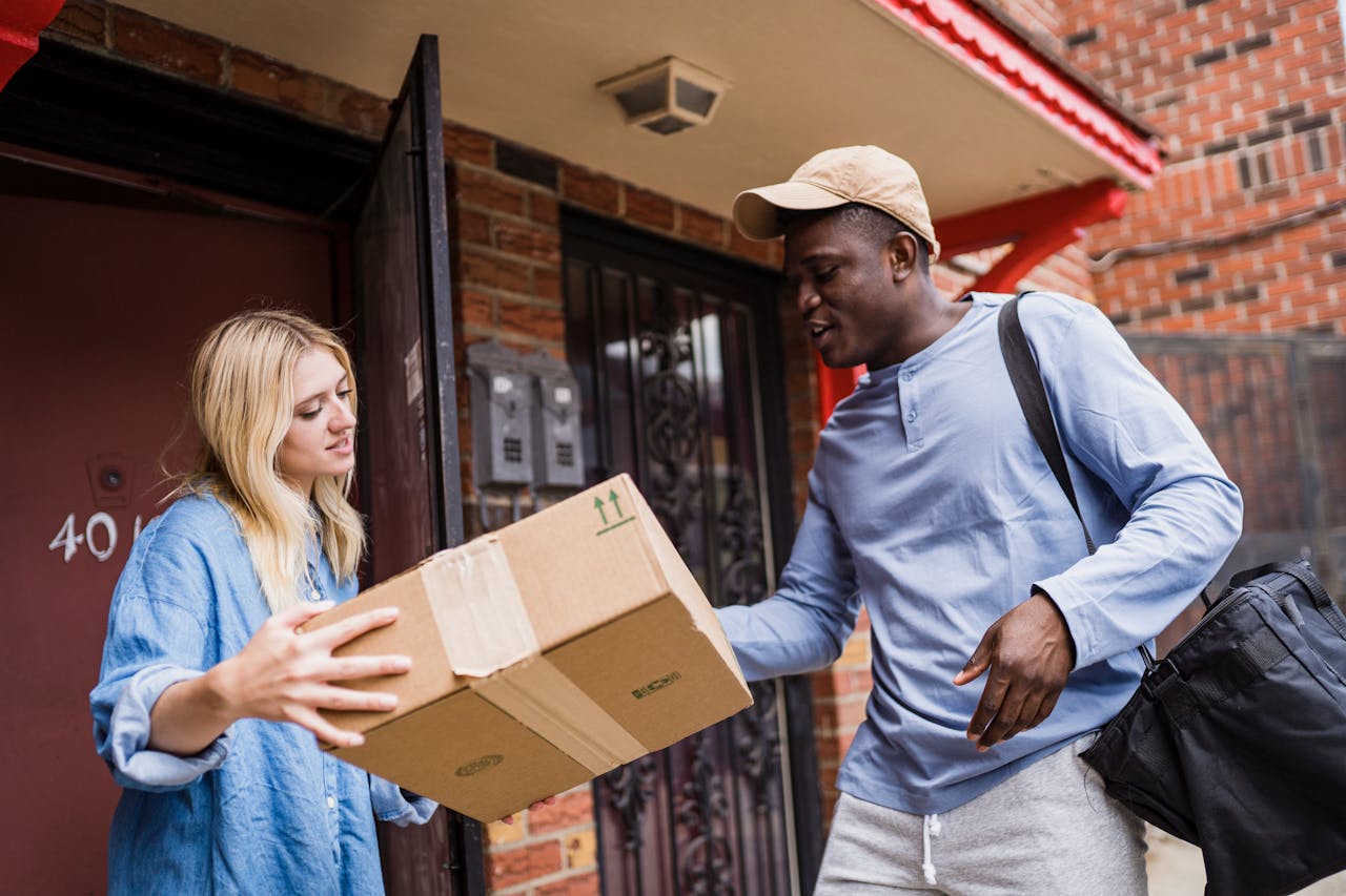 gallery-5 A delivery man handing a package to a woman at her doorstep, emphasizing delivery services.