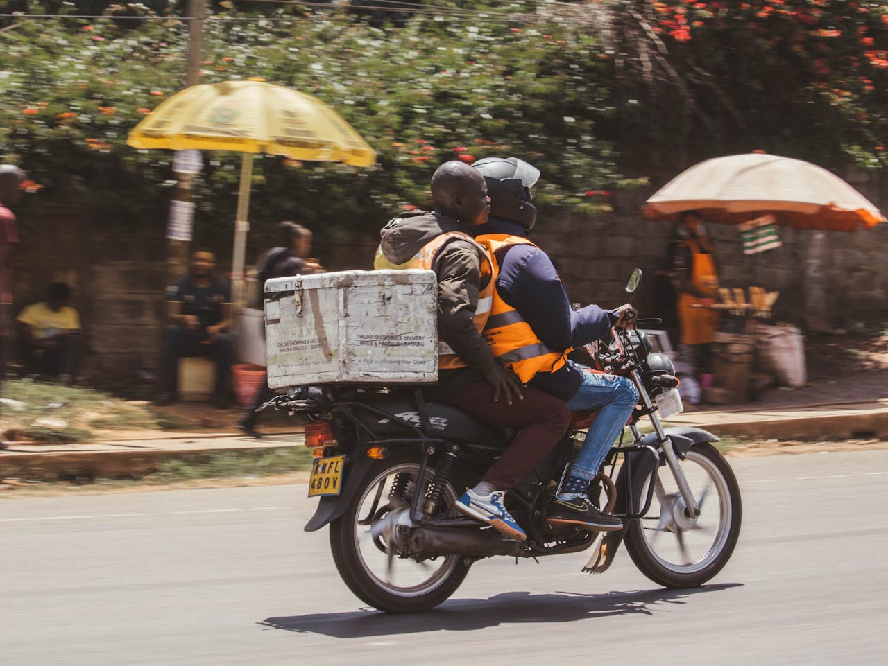 services-01 Motorcyclist and passenger delivering goods in Nairobi, Kenyas busy streets.